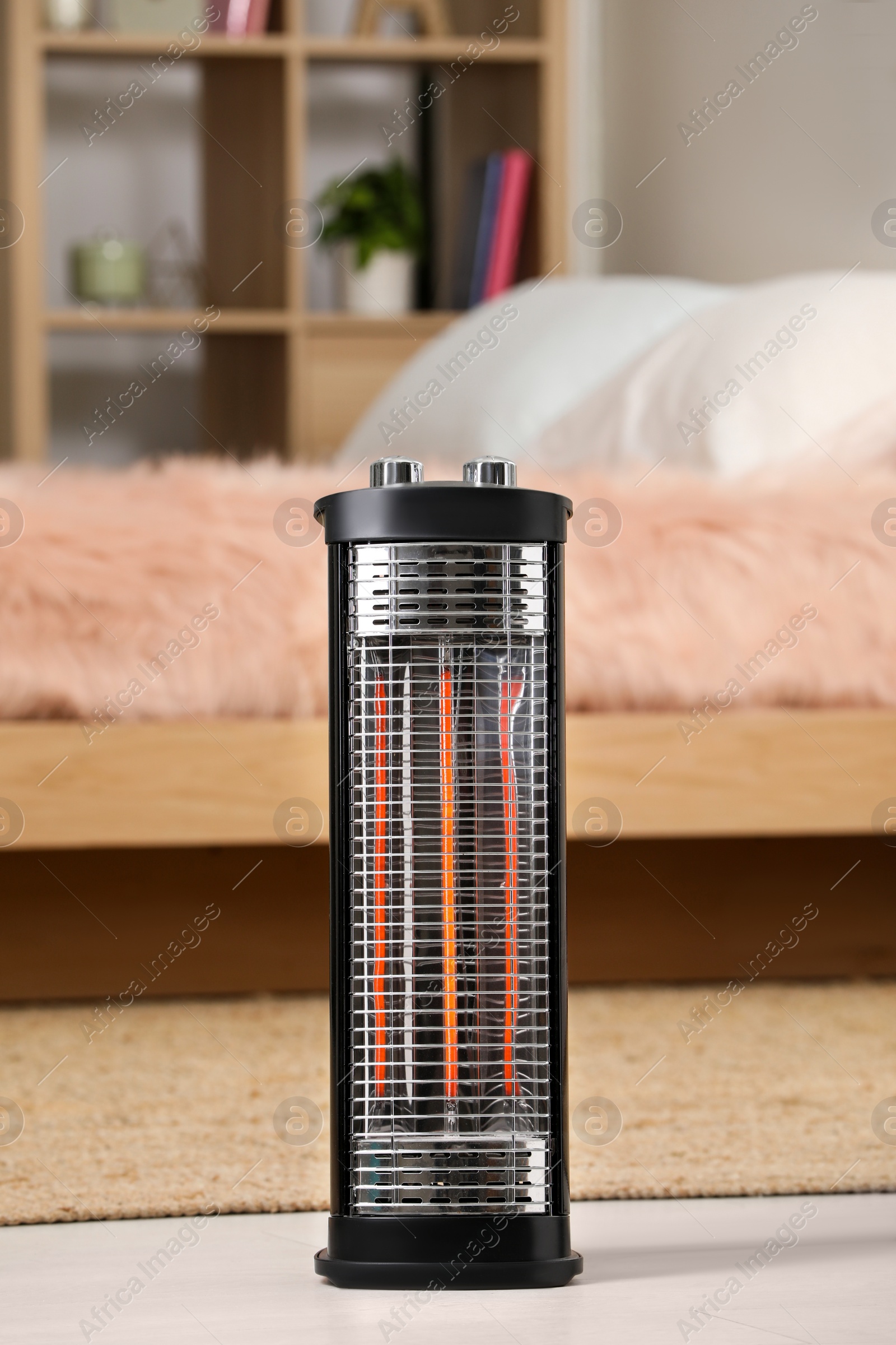 Photo of Modern infrared heater on floor in cozy room