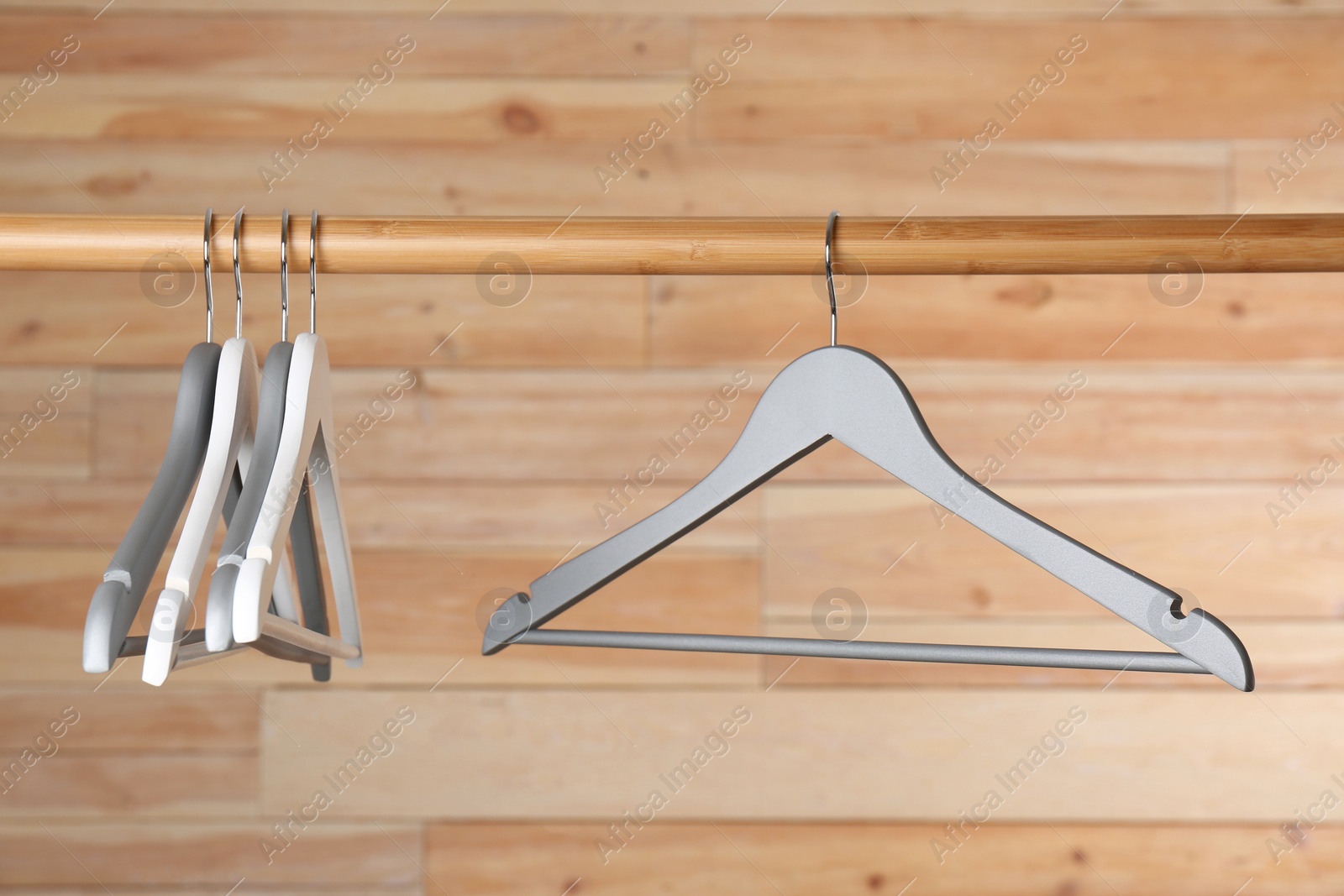 Photo of Rack with clothes hangers on wooden background