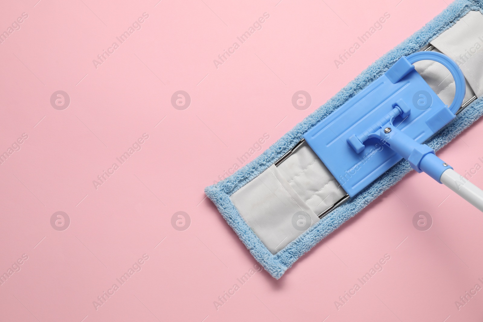 Photo of Mop with plastic handle on pink background, top view. Space for text