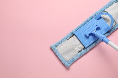 Mop with plastic handle on pink background, top view. Space for text