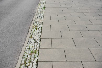 Photo of View on sidewalk near road. Footpath covering