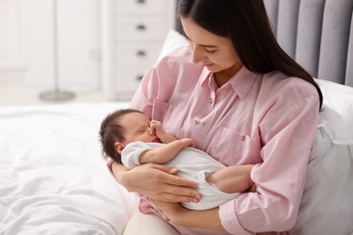 Photo of Mother with her sleeping newborn baby on bed at home