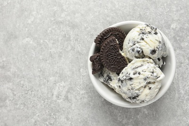 Bowl of chocolate cookies ice cream on grey background, top view with space for text