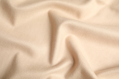 Photo of Beige soft cashmere fabric as background, closeup