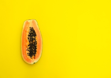 Fresh juicy halved papaya on yellow background, top view. Space for text