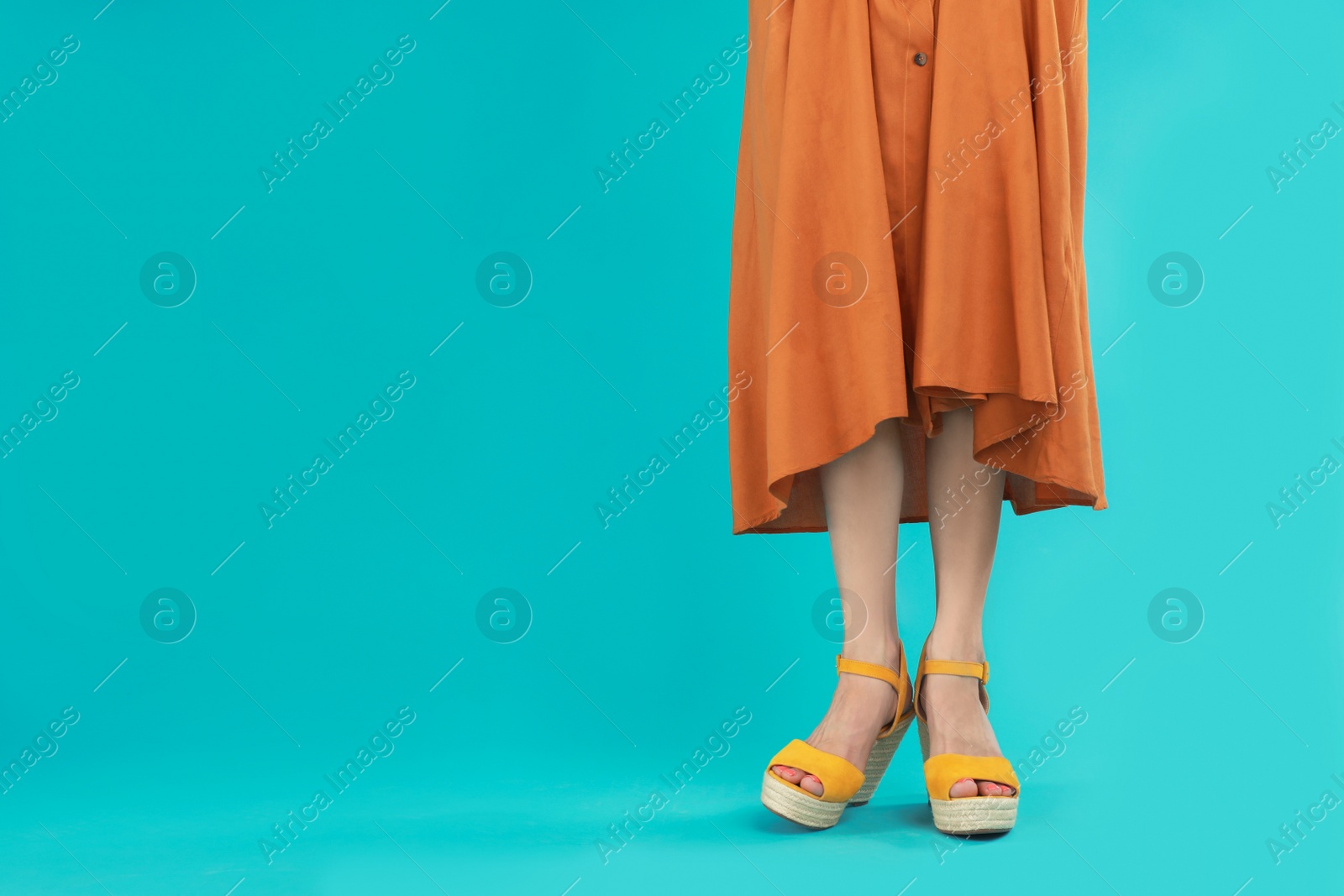 Photo of Woman in stylish shoes on light blue background. Space for text