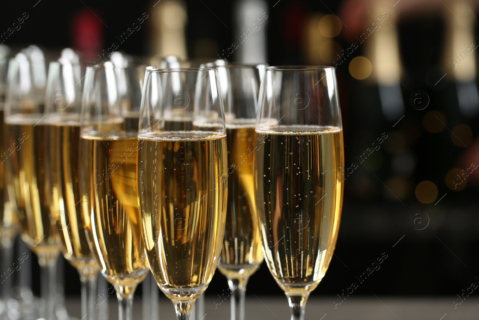 Photo of Many glasses of champagne on blurred background, closeup