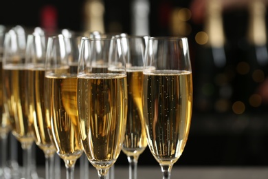 Photo of Many glasses of champagne on blurred background, closeup