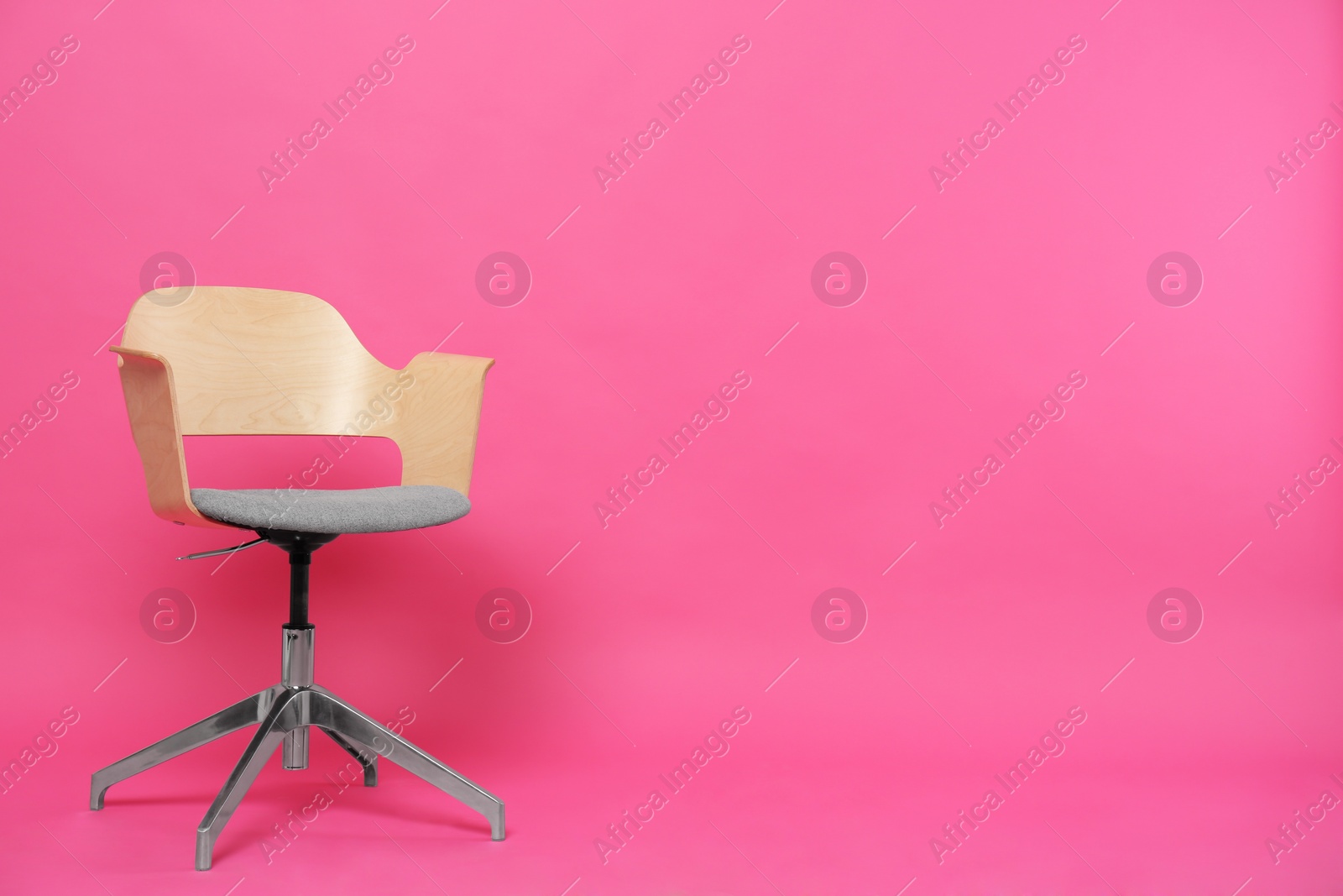 Photo of Comfortable office chair on pink background, space for text