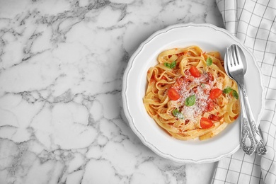 Photo of Tasty pasta and napkin on white marble table, flat lay. Space for text