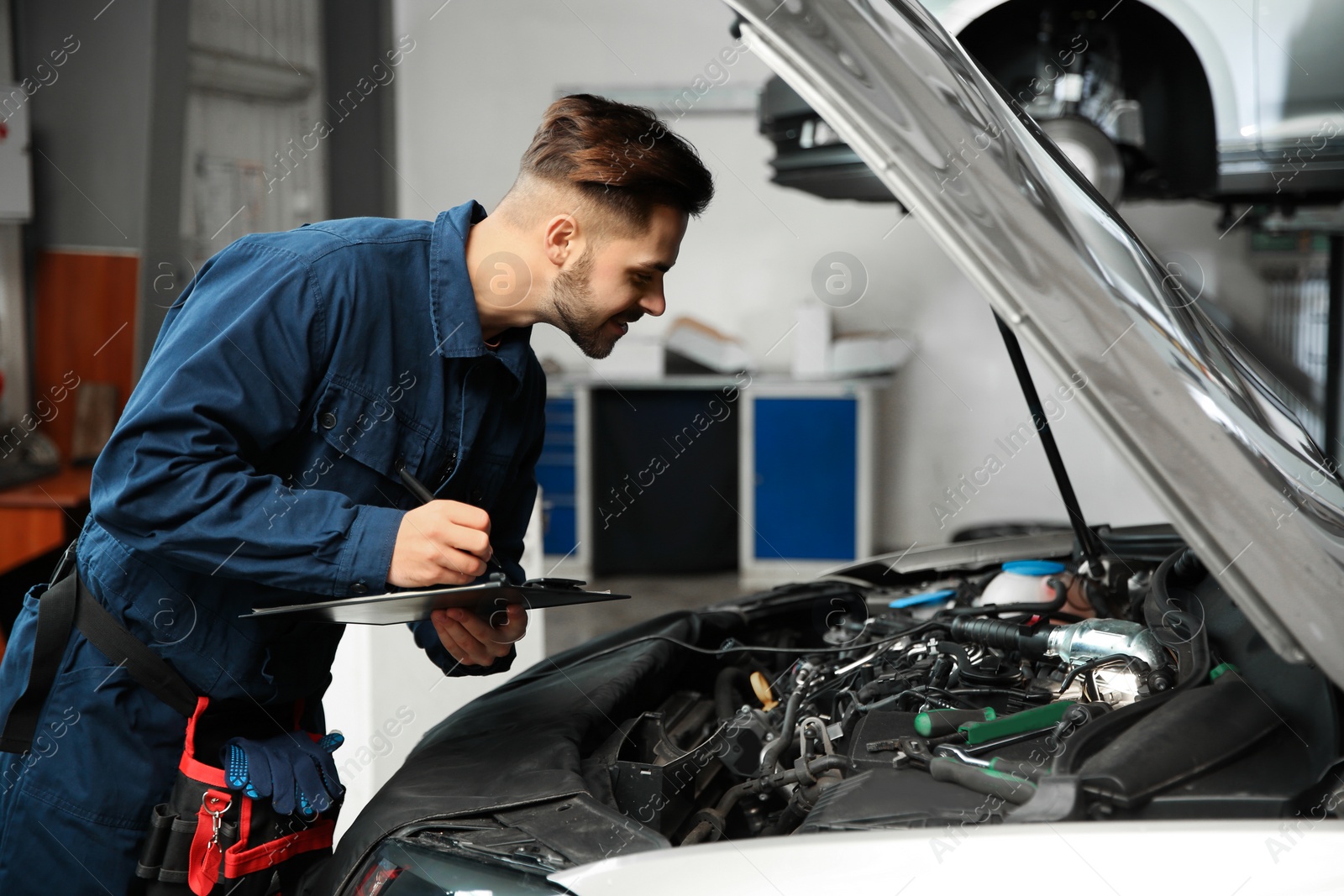 Photo of Technician checking modern car at automobile repair shop