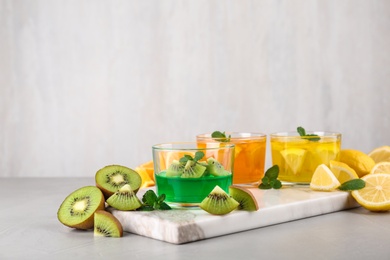 Photo of Glasses of tasty jelly served on light table. Space for text