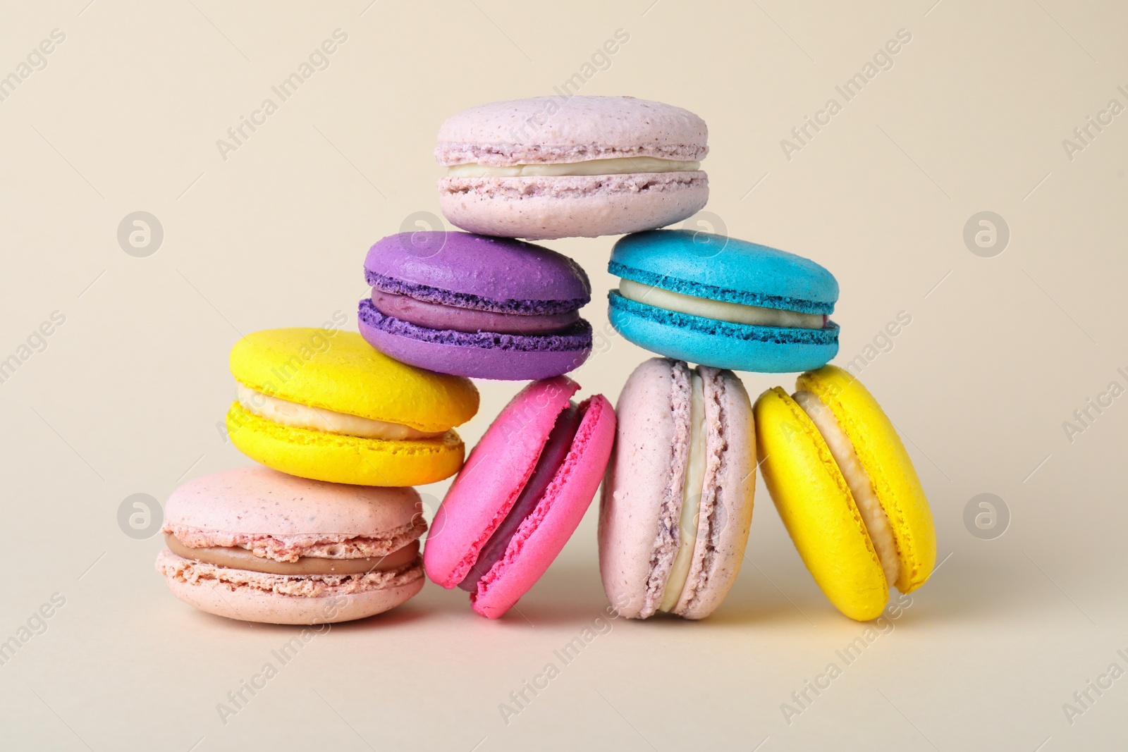 Photo of Delicious fresh colorful macarons on beige background