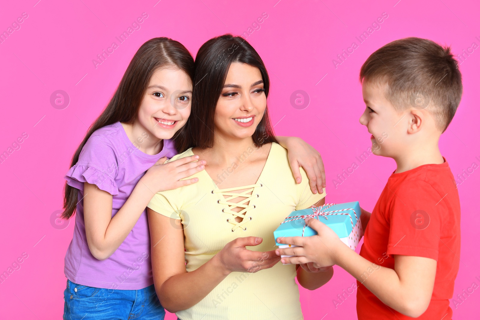 Photo of Son and daughter congratulating mom on color background. Happy Mother's Day