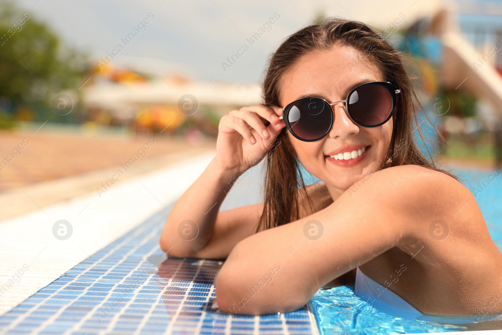 Photo of Young woman in outdoor swimming pool. Summer vacation