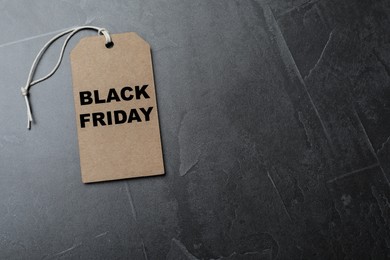 Photo of Tag with words Black Friday on grey table, top view. Space for text