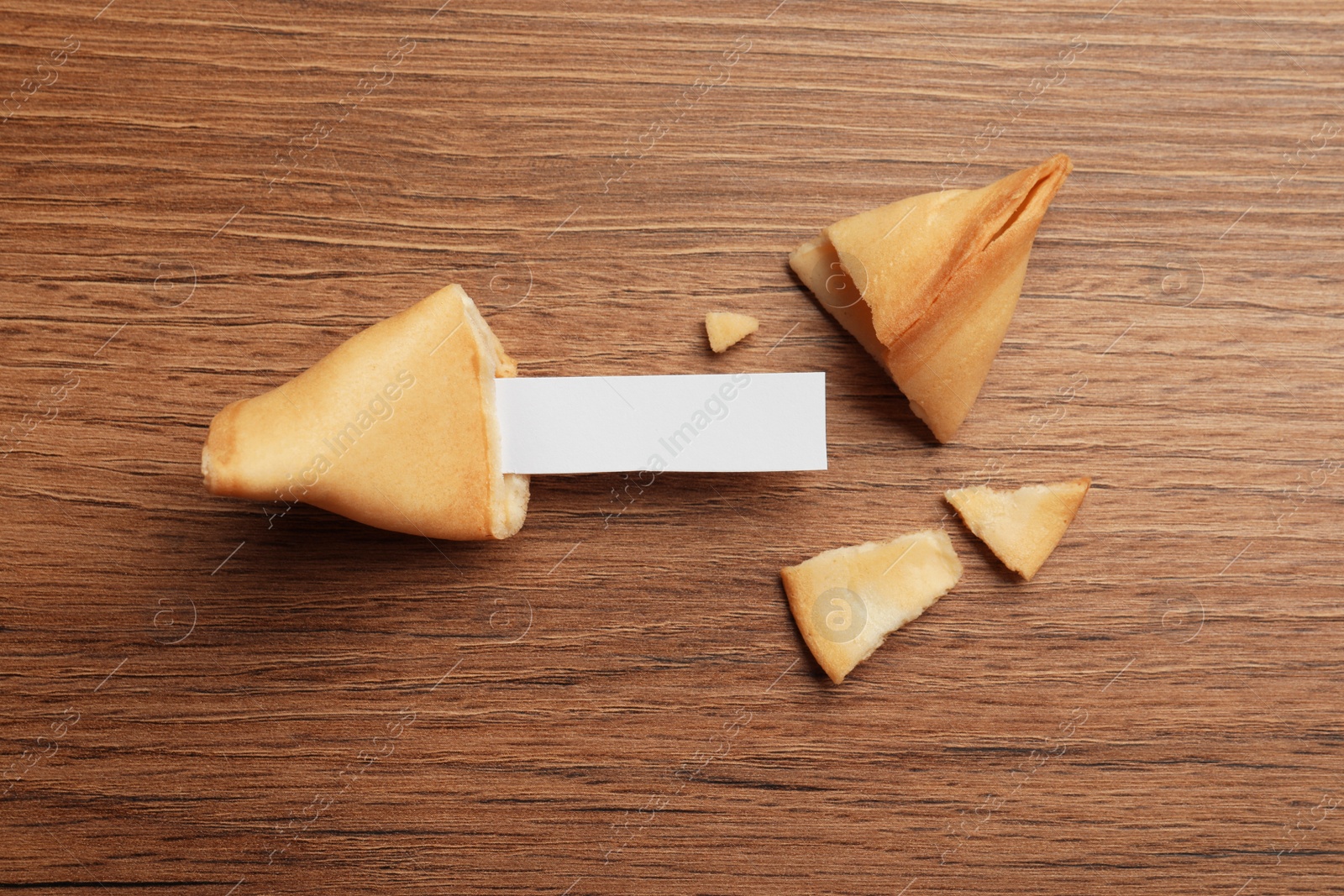 Photo of Tasty fortune cookies and paper with prediction on wooden table, flat lay. Space for text