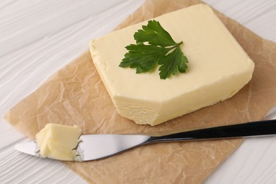 Photo of Tasty butter and knife on white wooden table