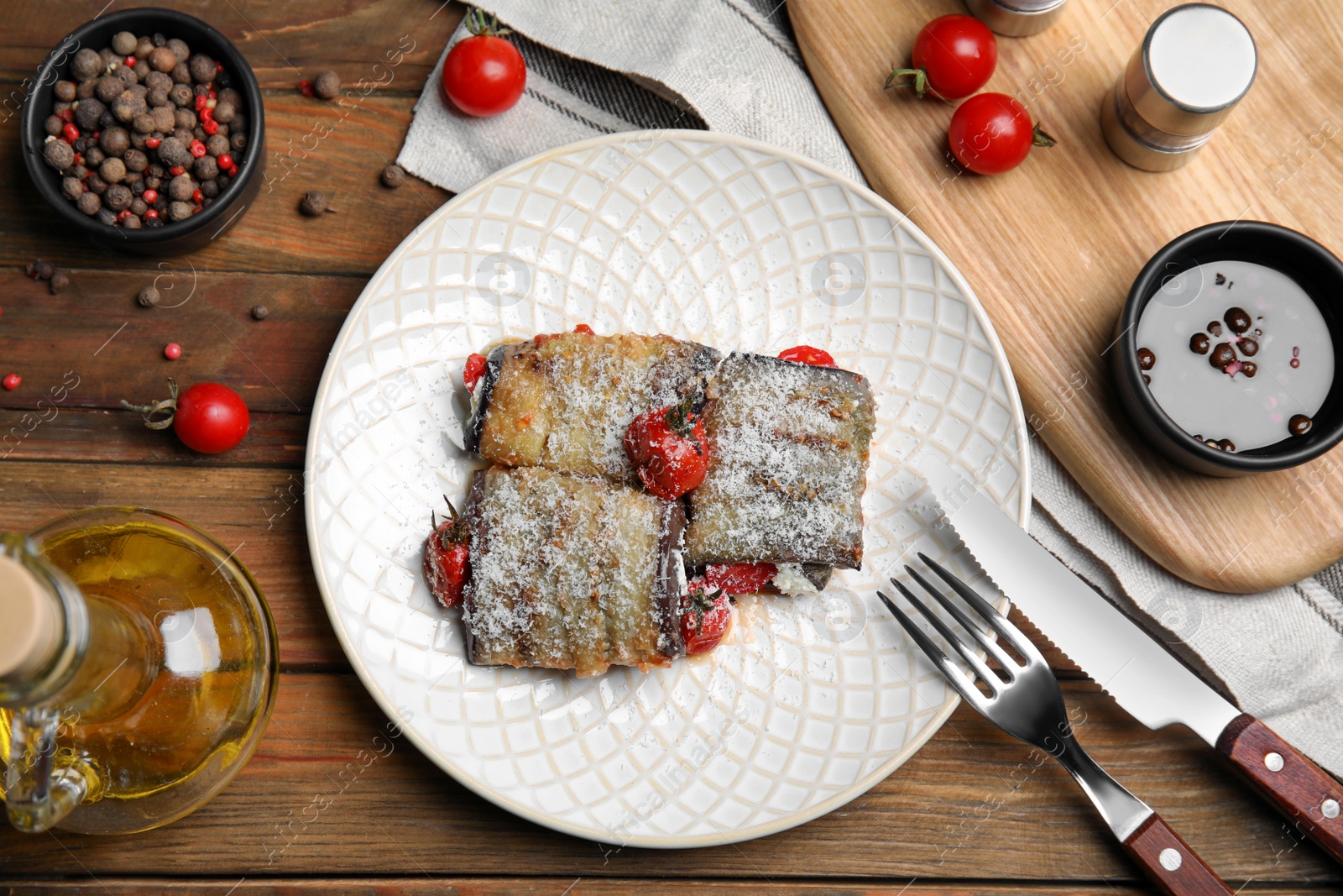 Photo of Delicious baked eggplant rolls served on wooden table, flat lay