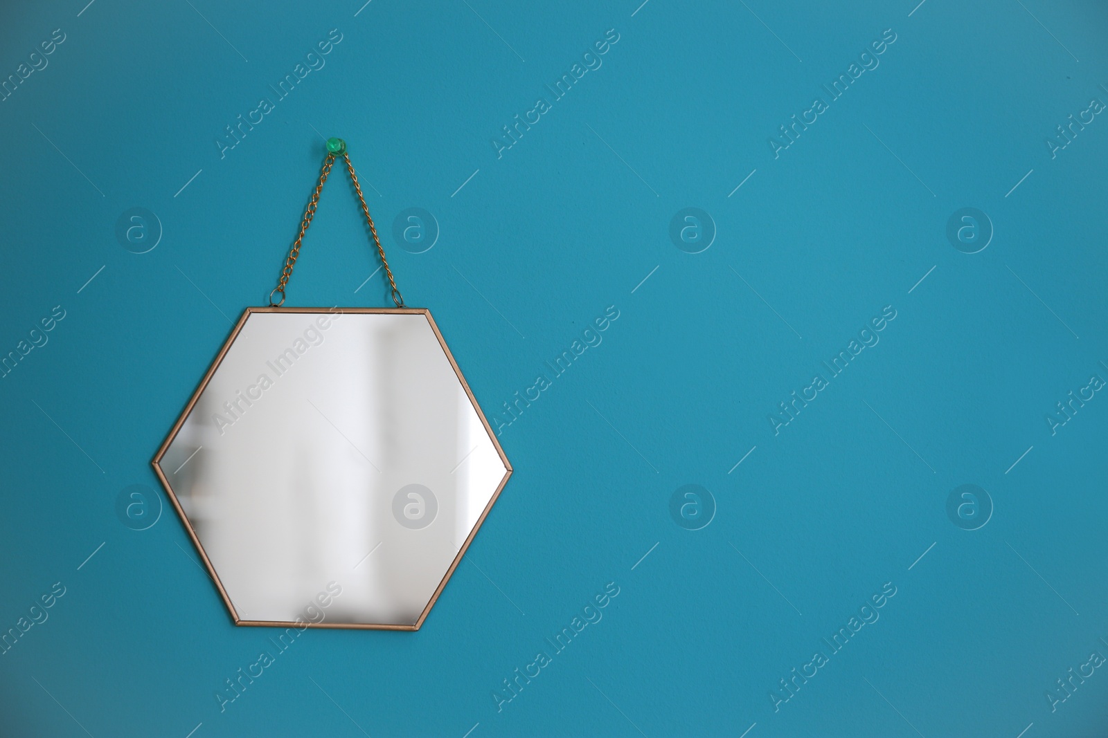 Photo of Mirror hanging on empty color wall