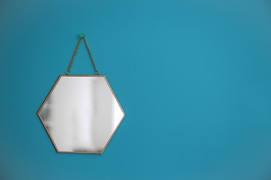 Photo of Mirror hanging on empty color wall
