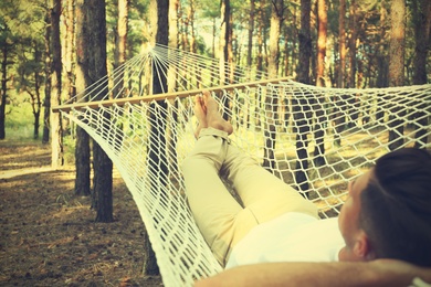 Man resting in hammock outdoors on summer day