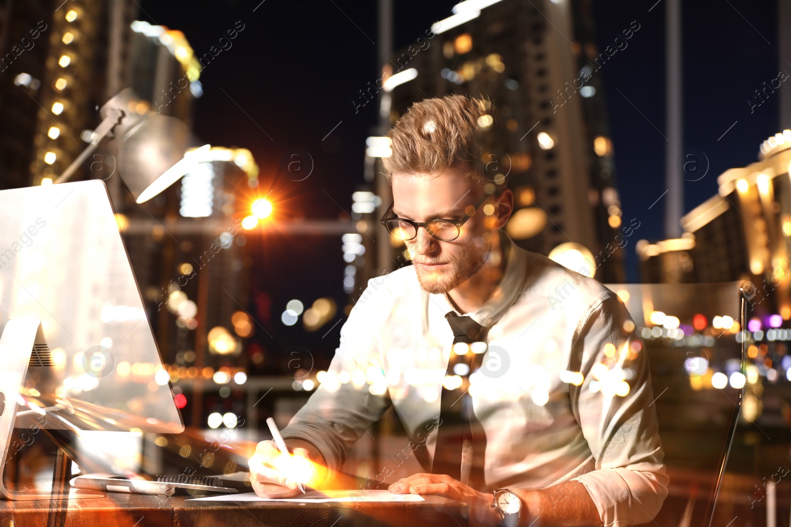 Image of Double exposure of young man working in office and night cityscape. Financial analytics