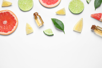 Photo of Flat lay composition with bottles of citrus essential oil on white background