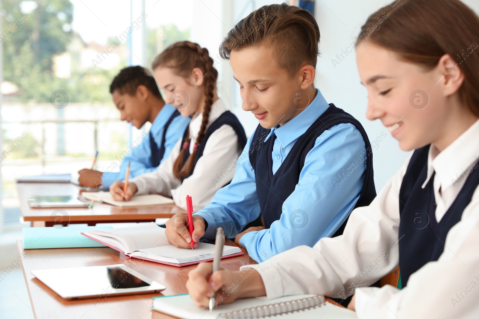 Photo of Teenage students in classroom. Stylish school uniform