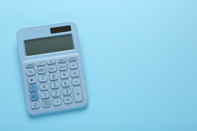 Modern calculator on light blue background, top view. Space for text