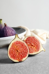 Photo of Fresh ripe fig sliced in half on table. Space for text