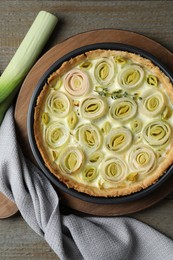 Photo of Tasty leek pie on wooden table, flat lay