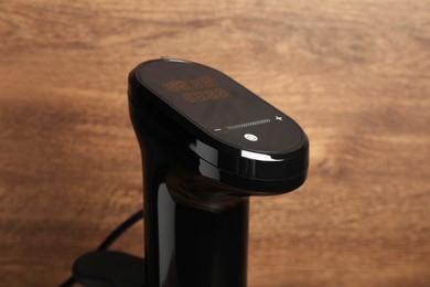 Photo of Thermal immersion circulator on wooden background, closeup. Sous vide cooker