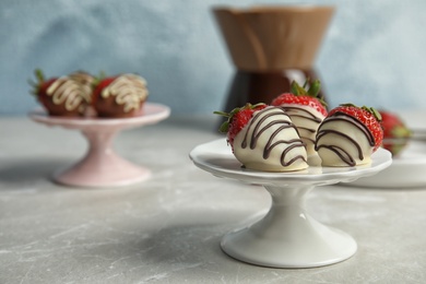 Photo of Dessert stand with chocolate covered strawberries on table