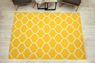 Stylish yellow carpet with pattern on floor in living room, above view