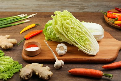 Photo of Fresh Chinese cabbages and ingredients on wooden table