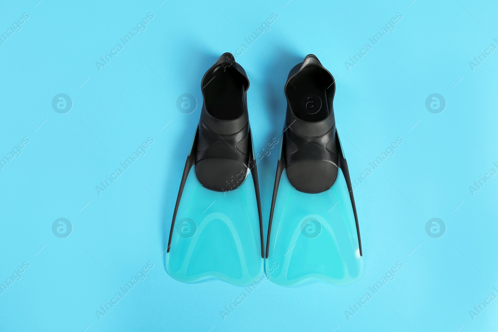 Photo of Swimming flippers on color background, top view