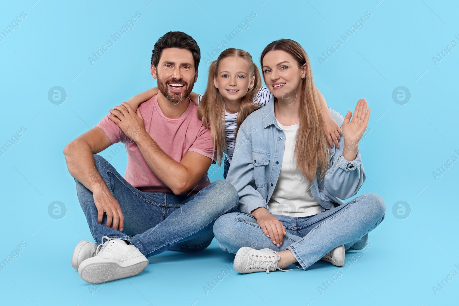 Photo of Happy family together on light blue background