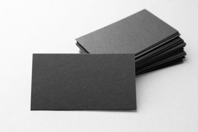 Photo of Blank black business cards on white table, closeup. Mockup for design