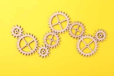 Photo of Business process organization and optimization. Scheme with wooden figures on yellow background, top view
