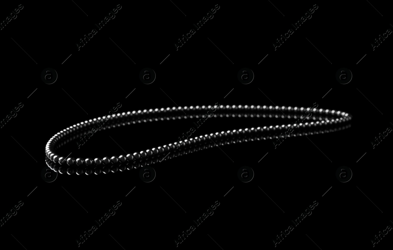 Photo of Chain of small magnetic balls on black background