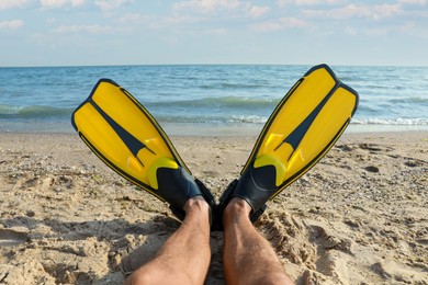 Photo of Man in flippers near sea on beach, closeup