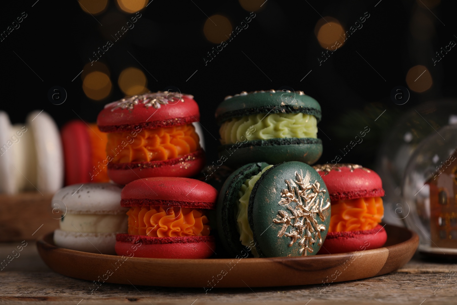 Photo of Beautifully decorated Christmas macarons and festive decor on wooden table, closeup