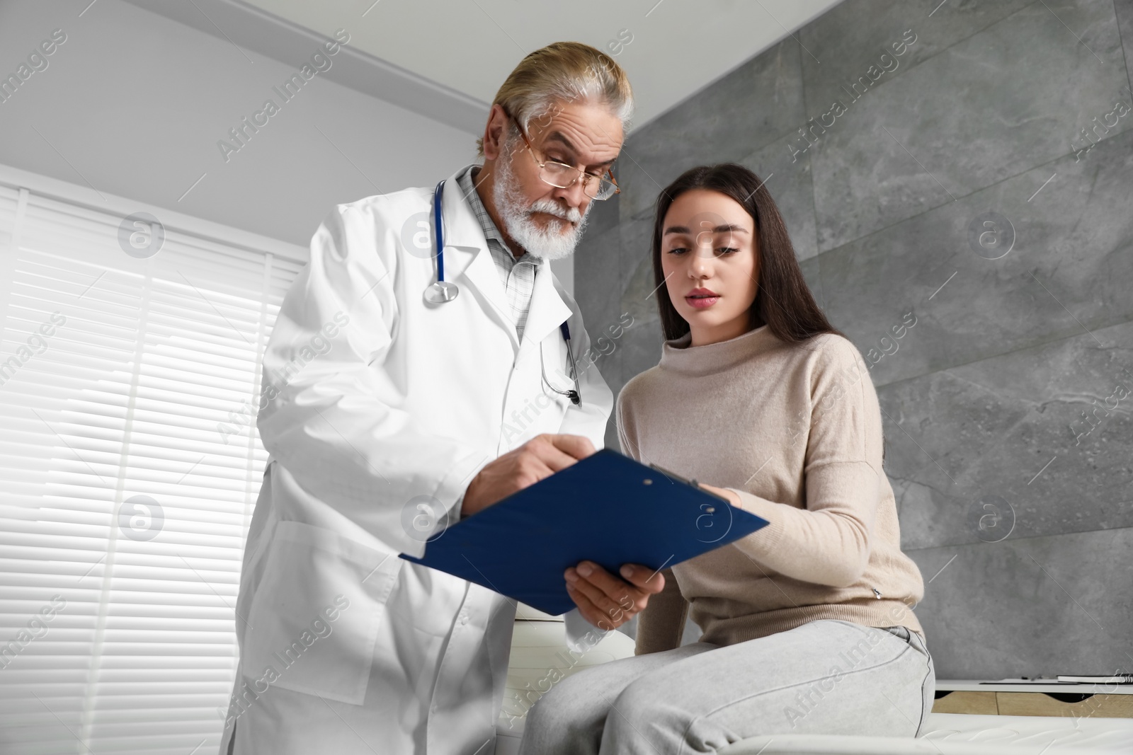 Photo of Patient having appointment with senior doctor in clinic, low angle view