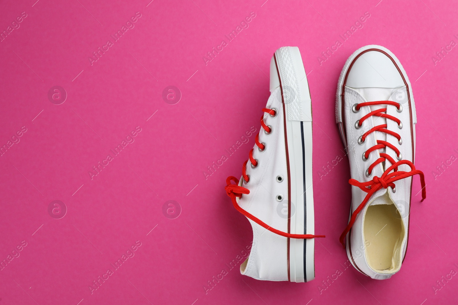 Photo of Pair of trendy sneakers on pink background, flat lay. Space for text