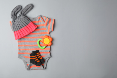 Photo of Flat lay composition with child's clothes and teether on grey background, space for text