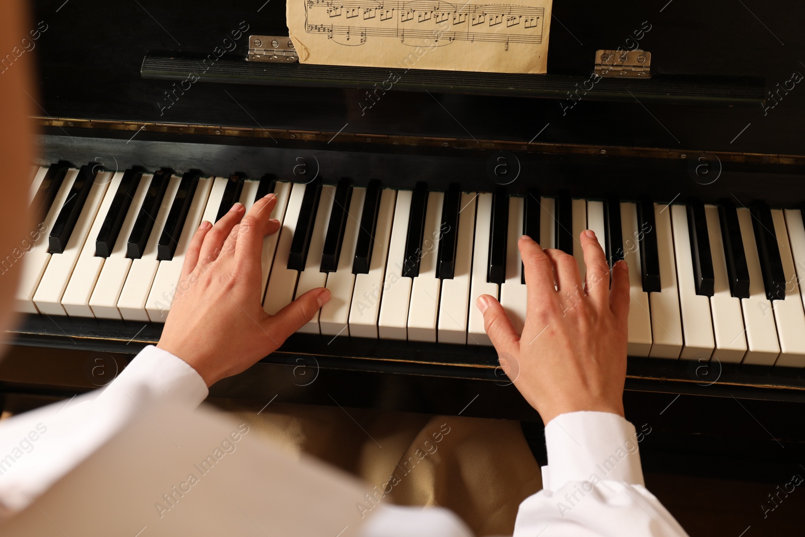 Photo of Young woman playing piano, closeup. Music lesson