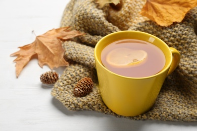 Composition with tea and warm plaid on white wooden table, closeup