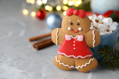Photo of Gingerbread girl on grey marble table, closeup. Space for text