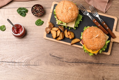 Photo of Flat lay composition with tasty hamburgers on wooden background. Space for text